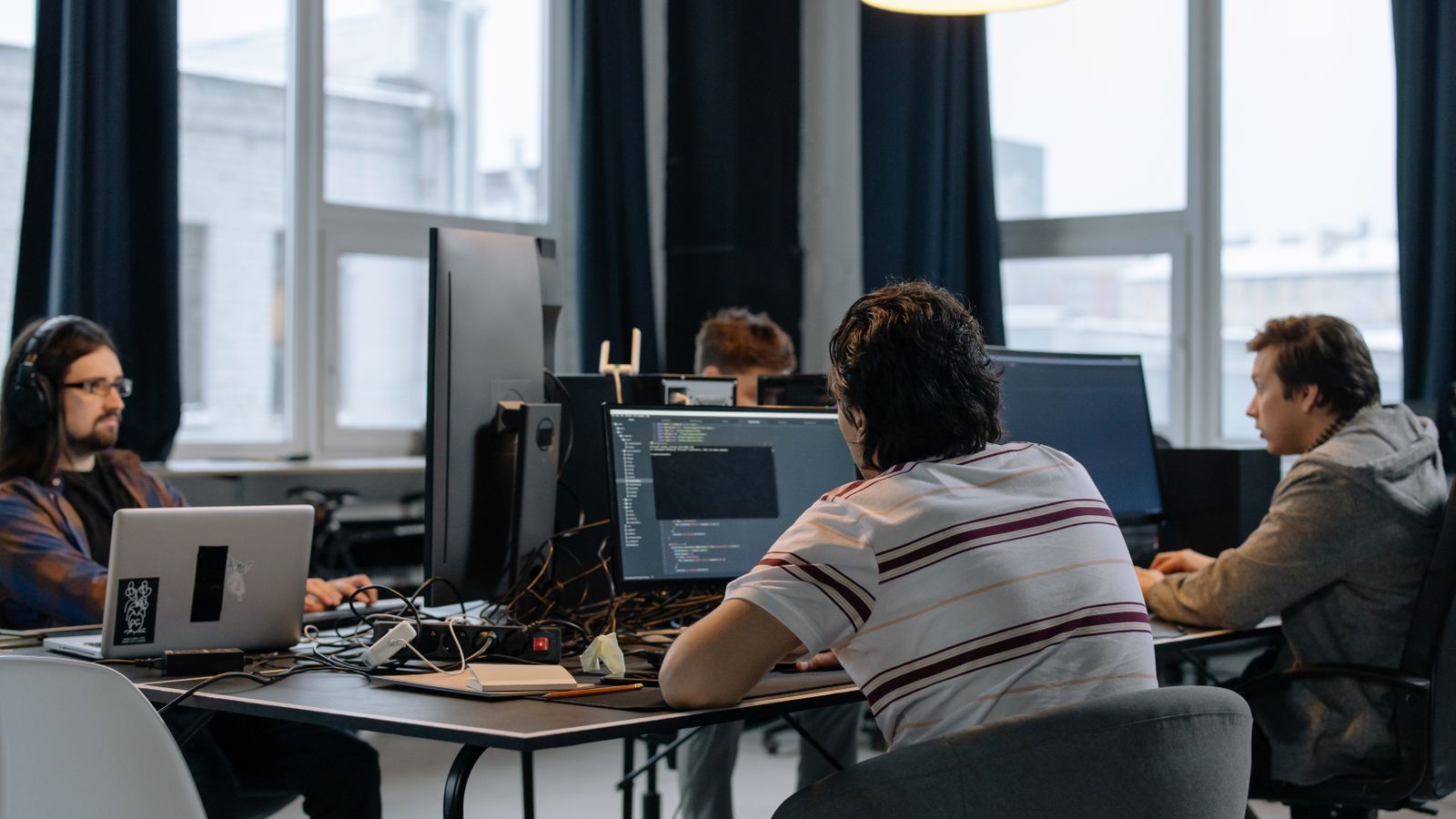 Equipo de desarrollo trabajando con código en una oficina moderna